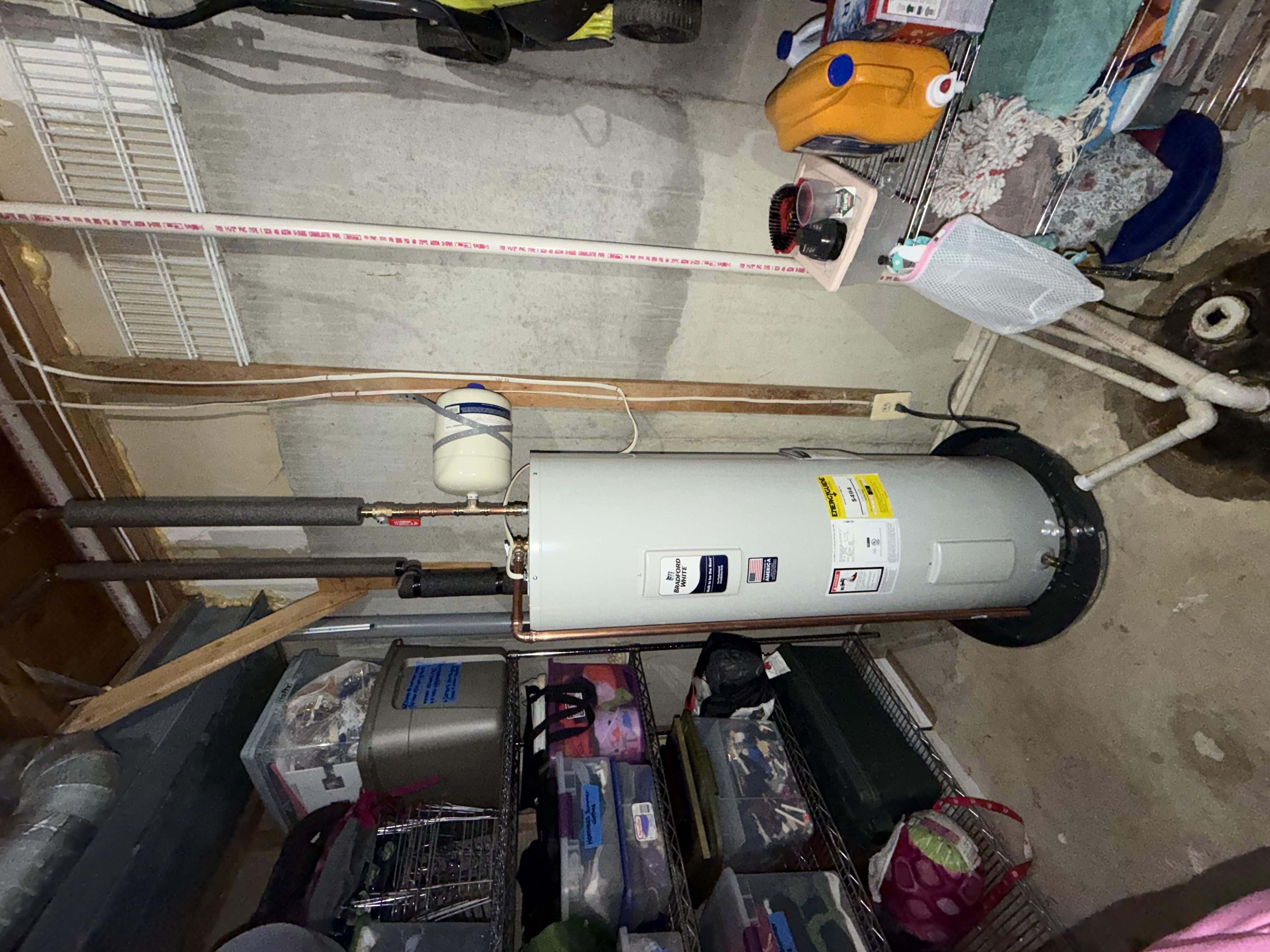 Bradford White 50-gallon installed — insulated hot side piping, strapped expansion tank, code compliant